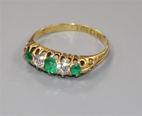 A George V 18ct gold emerald and diamond five stone half hoop ring, size P.